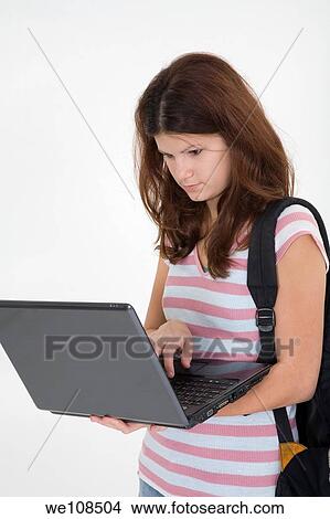 Picture - Portrait of Caucasian teen getting ready for school and working on laptop. Fotosearch