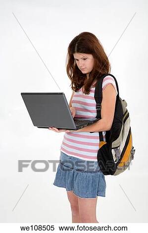 Stock Photography - Portrait of Caucasian teen getting ready for school and working on a laptop. Fotosearch