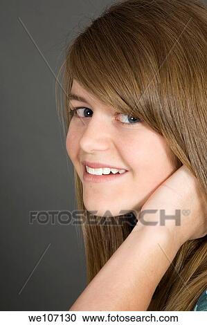Stock Image - Preteen girl posing on gray background with some attitude. Fotosearch