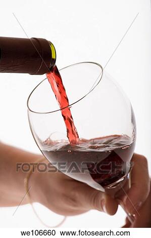 Red Wine pouring into glass with woman holding glass View Large Photo Image Stock Image - Red Wine pouring into glass with woman holding glass. Fotosearch