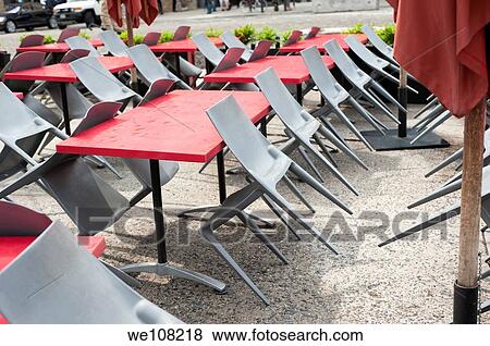 Rows of modern grey steel chairs leaning on red tables at a sidewalk cafe in New York City. View Large Photo Image Stock Photo - Rows of modern grey steel chairs leaning on red tables at a sidewalk cafe in New York City.. Fotosearch