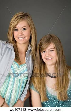 Stock Photo - Sisters posing on gray background with some attitude. Fotosearch