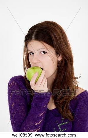 Stock Photo - Teenage girl eating a green apple. Fotosearch