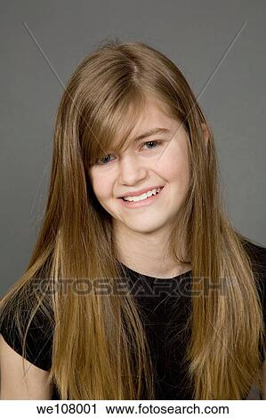 Teenage girl posing on a gray background with a smile View Large Photo Image Stock Image - Teenage girl posing on a gray background with a smile. Fotosearch