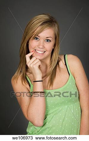 Stock Image - Teenage girl posing on gray background with some attitude. Fotosearch