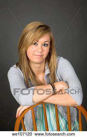 Stock Image - Teenage girl posing on gray background with some attitude. Fotosearch