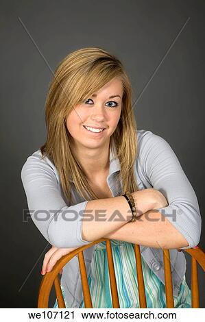 Stock Image - Teenage girl posing on gray background with some attitude. Fotosearch