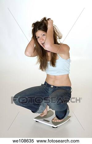 Teenage girl weighting herself and up set because her feels she is gaining weight View Large Photo Image Stock Photography - Teenage girl weighting herself and up set because her feels she is gaining weight. Fotosearch