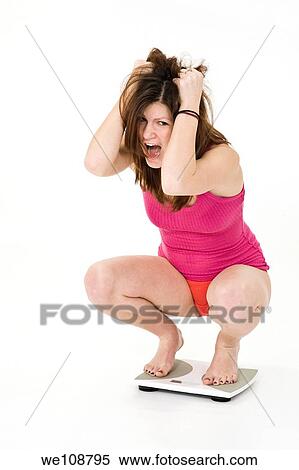 Teenage girl weighting herself and up set because her feels she is gaining weight View Large Photo Image Stock Photography - Teenage girl weighting herself and up set because her feels she is gaining weight. Fotosearch