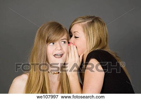 Teenage girls telling secrets posed in front of a gray background View Large Photo Image Stock Photo - Teenage girls telling secrets posed in front of a gray background. Fotosearch