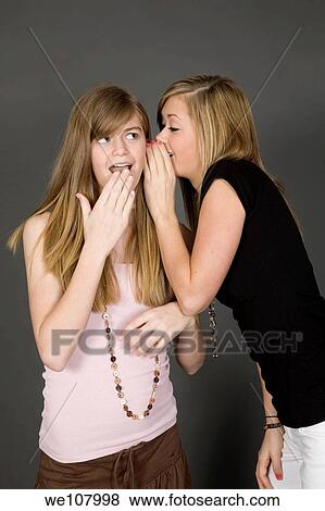 Teenage girls telling secrets posed in front of a gray background View Large Photo Image Stock Photo - Teenage girls telling secrets posed in front of a gray background. Fotosearch