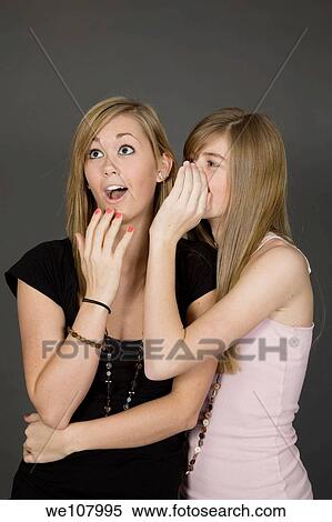 Teenage girls telling secrets posed in front of a gray background View Large Photo Image Stock Photography - Teenage girls telling secrets posed in front of a gray background. Fotosearch