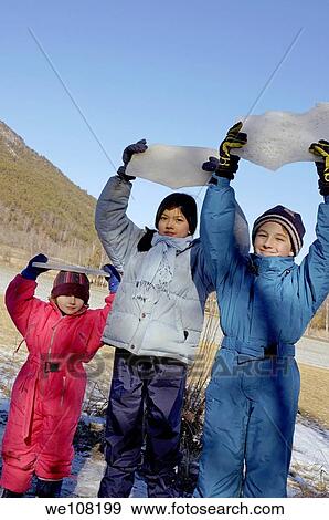 Three children holding a piece of ice as a trophy View Large Photo Image Stock Photo - Three children holding a piece of ice as a trophy. Fotosearch