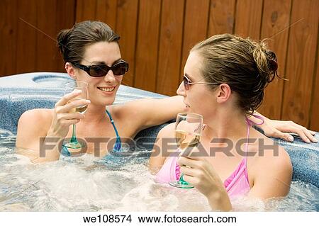 Two women in their mid 20s enjoying a relaxing moment in a hottub View Large Photo Image Picture - Two women in their mid 20s enjoying a relaxing moment in a hottub. Fotosearch