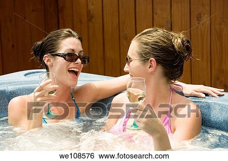 Two women in their mid 20s enjoying a relaxing moment in a hottub View Large Photo Image Stock Photograph - Two women in their mid 20s enjoying a relaxing moment in a hottub. Fotosearch
