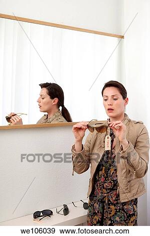 Stock Photo - Woman in a clothes shop. Fotosearch