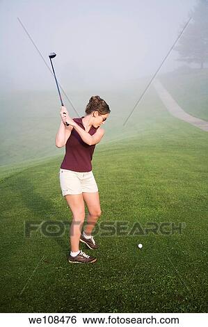 Woman in her mid 20s playing golf View Large Photo Image Stock Photograph - Woman in her mid 20s playing golf. Fotosearch