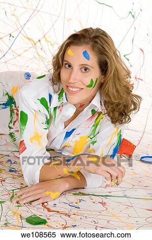 Woman in mid 20s having fun making a mess painting View Large Photo Image Stock Photography - Woman in mid 20s having fun making a mess painting. Fotosearch