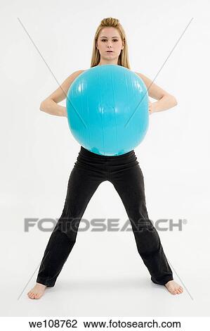 Stock Image - Young blonde woman exercising on a white background. Fotosearch