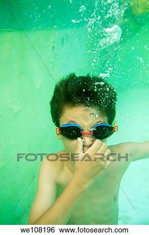 Young boy wearing swimming goggles and holding his breath underwater in a pool, Provence, France View Large Photo Image Stock Photograph - Young boy wearing swimming goggles and holding his breath underwater in a pool, Provence, France. Fotosearch