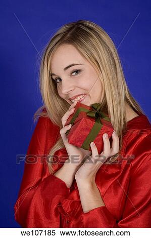 Stock Photography - Young woman excited after recieving a special gift. Fotosearch