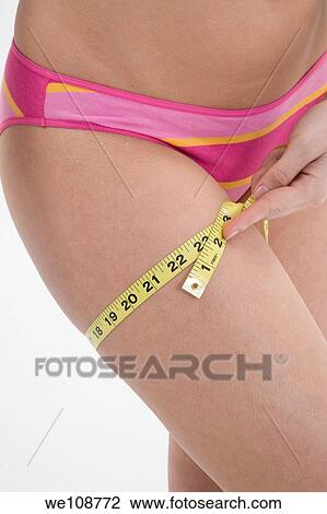 Young woman in underwear measuring her leg View Large Photo Image Stock Image - Young woman in underwear measuring her leg. Fotosearch