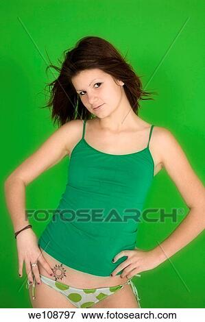 Young woman posing in front of a green background in a tank top and panties View Large Photo Image Stock Photo - Young woman posing in front of a green background in a tank top and panties. Fotosearch