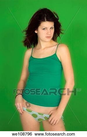 Young woman posing in front of a green background in tank top and panties View Large Photo Image Stock Photograph - Young woman posing in front of a green background in tank top and panties. Fotosearch
