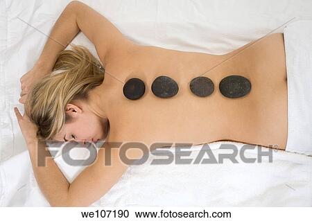 Young woman relaxing during a message using stone therapy View Large Photo Image Stock Image - Young woman relaxing during a message using stone therapy. Fotosearch