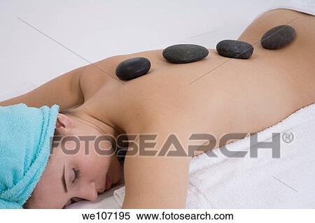 Young woman relaxing during a message using stone therapy View Large Photo Image Stock Photography - Young woman relaxing during a message using stone therapy. Fotosearch