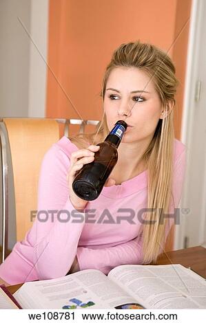 Young woman relaxing in the kitchen drinking a beer Underage drinking View Large Photo Image Stock Image - Young woman relaxing in the kitchen drinking a beer Underage drinking. Fotosearch