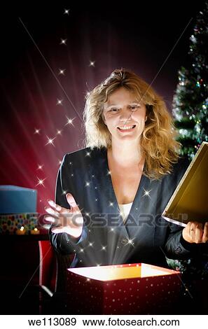 Blond woman opening Christmas present View Large Photo Image Stock Photo - Blond woman opening Christmas present. Fotosearch