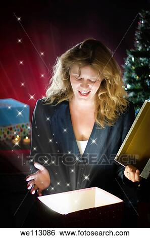 Christmas Joy - A woman is opening a present View Large Photo Image Stock Photograph - Christmas Joy - A woman is opening a present. Fotosearch
