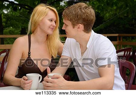 Couple of lovers talking while sitting at an outdoor cafe near a park View Large Photo Image Stock Photography - Couple of lovers talking while sitting at an outdoor cafe near a park. Fotosearch