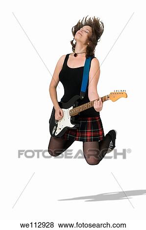 Stock Photo - Female guitarist jumps. Fotosearch