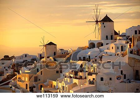 Stock Photo - Oia Ia Santorini - Windmills and town at sunset, Greek Cyclades islands - Photos, pictures and images. Fotosearch