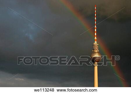 Stock Photo - Rainbow over the TV Tower on a cloudy sky in Berlin Mitte. Fotosearch