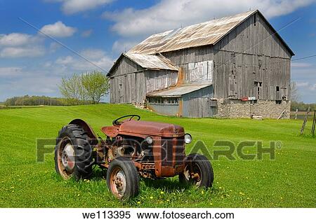 Rusted tractor and old barn in grass field and blue sky in rural Ontario View Large Photo Image Stock Photography - Rusted tractor and old barn in grass field and blue sky in rural Ontario. Fotosearch