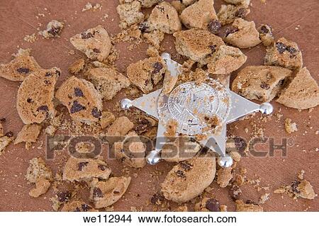Sheriff´s badge among broken chocolate chip cookies View Large Photo Image Picture - Sheriff´s badge among broken chocolate chip cookies. Fotosearch
