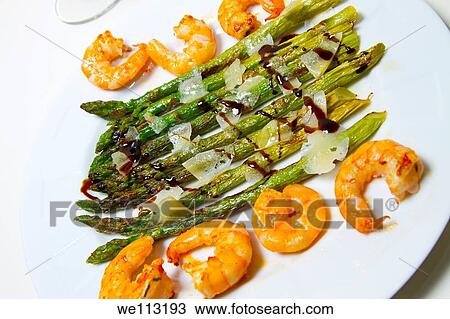 Stock Image - wild asparagus sautted with prawns, cheese slices. Fotosearch