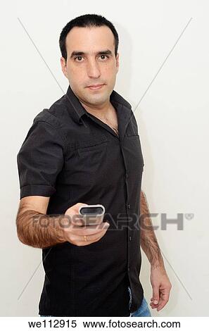 Young man in his thirties with a remote control View Large Photo Image Stock Photography - Young man in his thirties with a remote control. Fotosearch