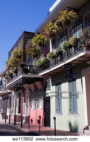 Stock Image - Creole townhouses with ornate wrought iron balcony and hanging planters and window boxes in the French Quarter of New Orleans, Louisiana. Fotosearch