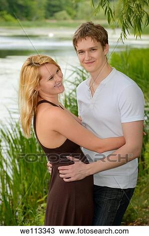 Happy eastern European couple in love embracing by the shore of a lake View Large Photo Image Stock Image - Happy eastern European couple in love embracing by the shore of a lake. Fotosearch