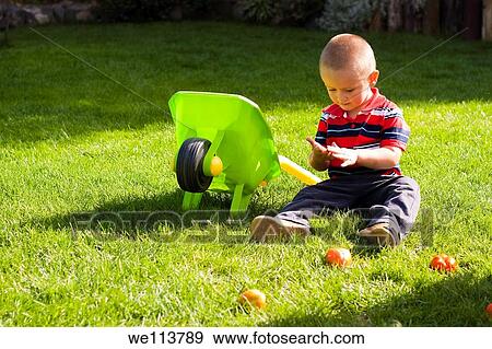 Little boy with toy barrow playing in the gardening View Large Photo Image Stock Photo - Little boy with toy barrow playing in the gardening. Fotosearch