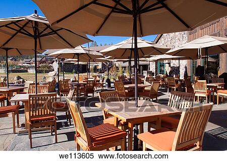 Outdoor patio dining at a mountain resort lodge with umbrellas over wood tables and chairs View Large Photo Image Stock Photography - Outdoor patio dining at a mountain resort lodge with umbrellas over wood tables and chairs. Fotosearch