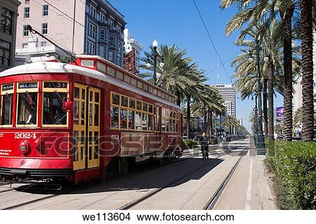 Red trolley car and bicycle on the tracks on Canal Street in downtown New Orleans, Louisiana View Large Photo Image Picture - Red trolley car and bicycle on the tracks on Canal Street in downtown New Orleans, Louisiana. Fotosearch