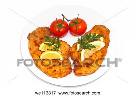 Schnitzels with lemons and tomatoes on plate, isolated on white background View Large Photo Image Stock Photo - Schnitzels with lemons and tomatoes on plate, isolated on white background. Fotosearch