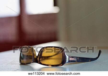 Sunglasses on table, indoors View Large Photo Image Picture - Sunglasses on table, indoors. Fotosearch