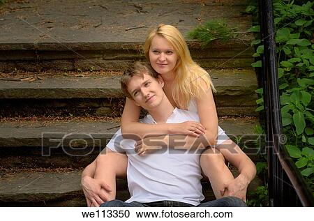 Two fair lovers sitting on stone steps in a woodland park View Large Photo Image Stock Image - Two fair lovers sitting on stone steps in a woodland park. Fotosearch