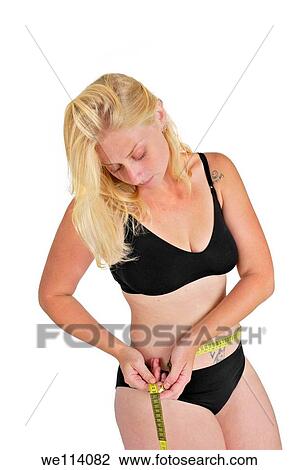 Eating disorder and body image young woman measures her hip with a tape measure She may be keeping track of weight loss during a diet but compulsive body analysis may be a symptom of a body image disorder such as anorexia nervosa Model released View Large Photo Image Stock Image - Eating disorder and body image young woman measures her hip with a tape measure She may be keeping track of weight loss during a diet but compulsive body analysis may be a symptom of a body image disorder such as anorexia nervosa Model released. Fotosearch